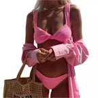 Biquíni rosa texturizado com camisa rosa e bolsa de palha em look praiano elegante para o verão.