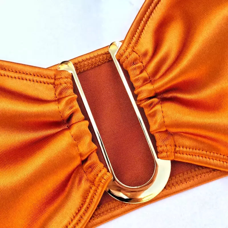 Vista de perto sutiã biquíni laranja com detalhes em dourado