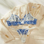 Lingerie detalhada em renda azul floral e acabamento bege.