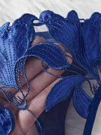 Detalhe de renda floral azul marinho sobre tela transparente em lingerie delicada