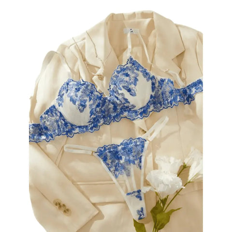 Lingerie detalhada em bege com acabamento em renda floral azul.