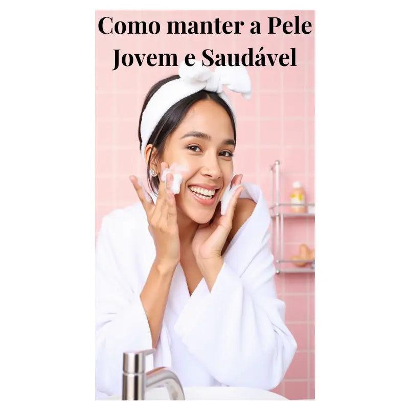 Jovem sorridente em roupão branco aplicando espuma de limpeza facial, demonstrando rotina para manter pele jovem e viçosa.