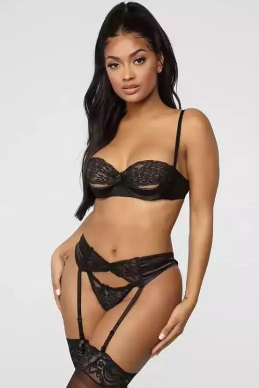Conjunto lingerie preto em renda floral com sutiã meia taça e calcinha cinta-liga sensual.