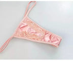 Calcinha rosa de renda e cetim com detalhes delicados.