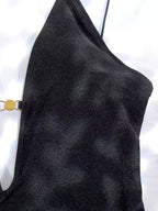 Detalhe do bojo estruturado do maiô preto com alça fina e pingente dourado lateral