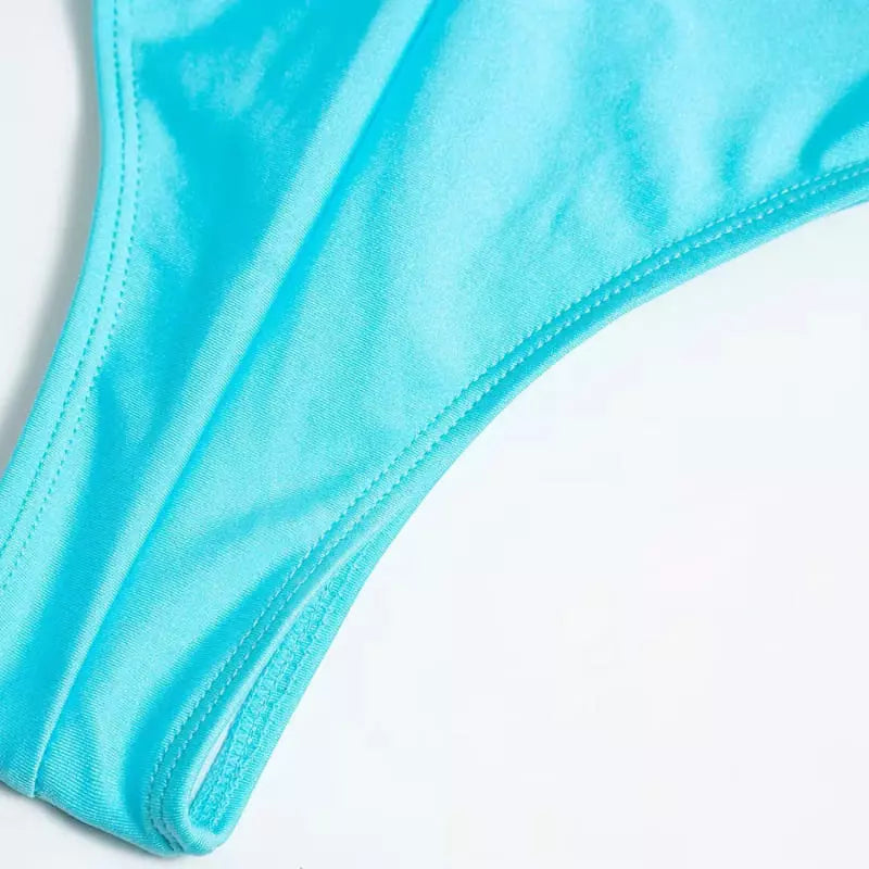 Detalhe maiô cavado azul turquesa com costura reforçada e tecido premium em fundo branco