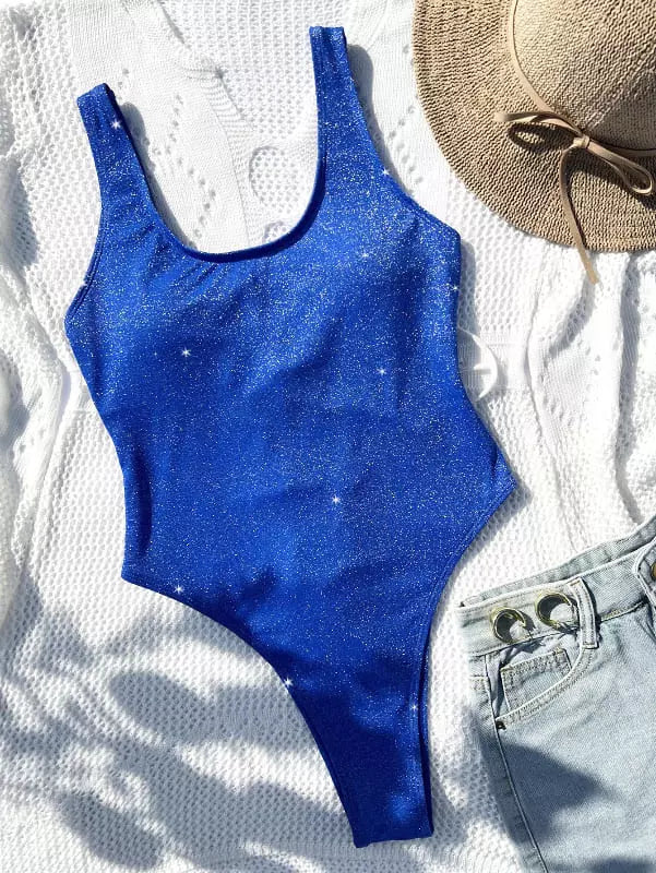 Maiô azul brilhante inteiro com alças largas, combinado com chapéu de palha e shorts jeans