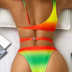 Detalhe biquíni degradê verde-amarelo-laranja com fivela dourada nas costas em sofá branco