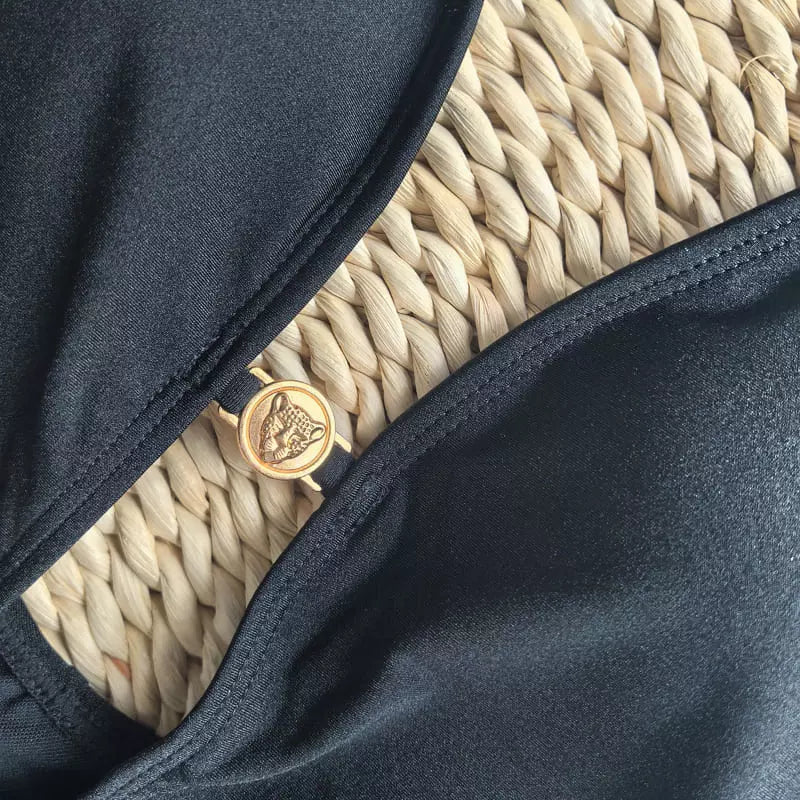 Detalhe do pingente dourado decorativo do maiô preto com acabamento premiumTentar novamente