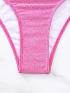 Detalhe close-up calcinha rosa com brilho e textura sobre mármore branco 