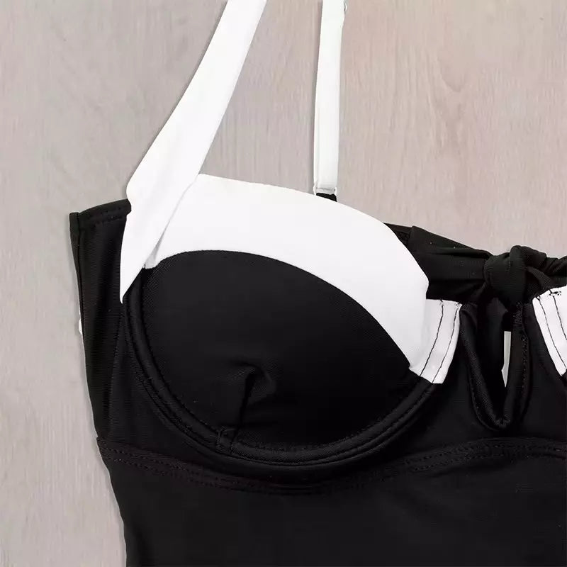 Detalhe de maiô preto com bojo estruturado, alças brancas e acabamento com laço lateral