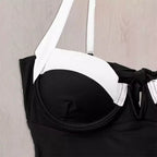 Detalhe de maiô preto com bojo estruturado, alças brancas e acabamento com laço lateral