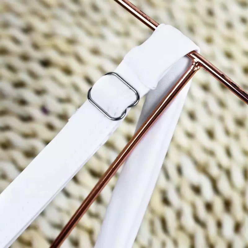 Detalhe de alça branca ajustável de maiô com fivela metálica e acabamento de qualidade