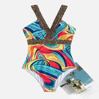 Maiô estampado com padrão abstrato multicolorido em tons de azul, vermelho e amarelo, alças cruzadas.