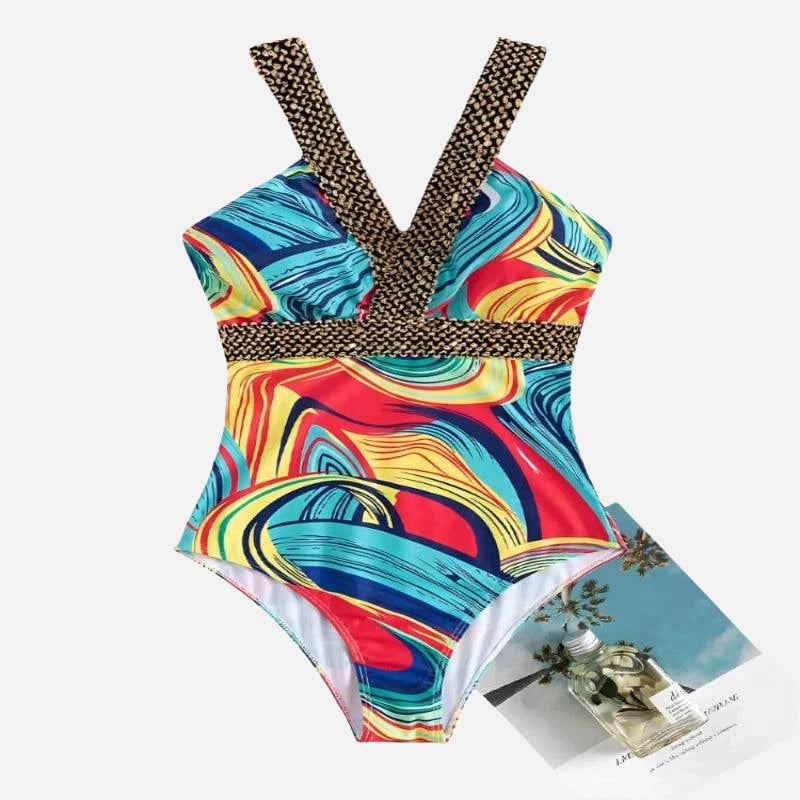 Maiô estampado com padrão abstrato multicolorido em tons de azul, vermelho e amarelo, alças cruzadas.