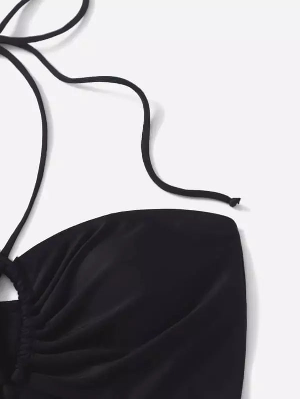 Detalhe de top de maiô preto com alça de amarrar no pescoço em fundo branco