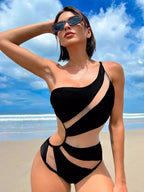 Biquíni preto assimétrico com recortes modernos, mulher de óculos na praia, moda praia elegante.