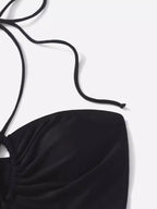 Detalhe de top de maiô preto com alça de amarrar no pescoço em fundo branco