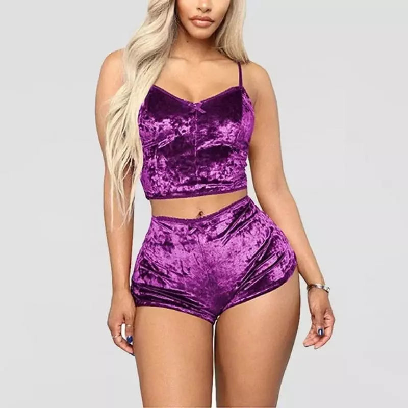 Conjunto de pijama em veludo roxo, com top de alças e shorts curto, em fundo neutro, ideal para dormir com conforto.