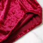 Tecido de veludo vermelho cereja com detalhe da costura e acabamento, mostrando a textura macia e brilho luxuoso.