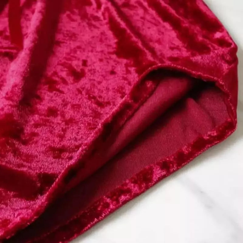 Tecido de veludo vermelho cereja com detalhe da costura e acabamento, mostrando a textura macia e brilho luxuoso.