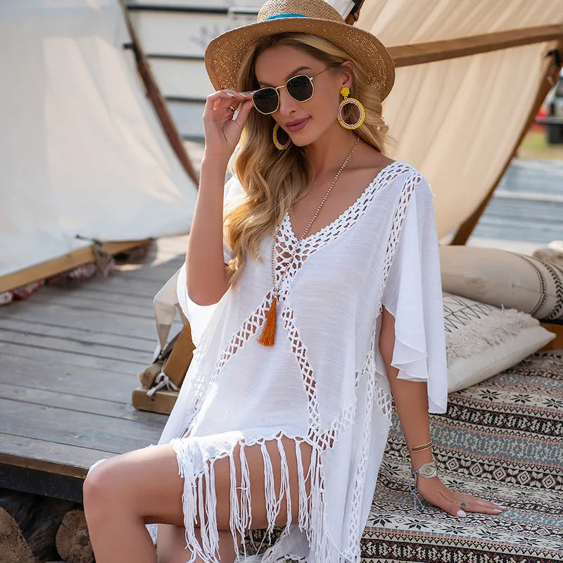 Saída crochê branca com franjas, vista lateral de modelo elegante e sofisticado para praia