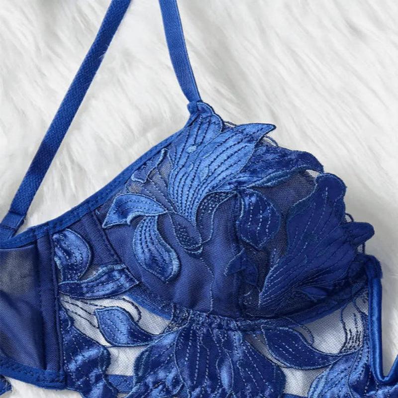 Detalhe de sutiã feminino de renda azul escuro com design floral modificado e acabamento delicado