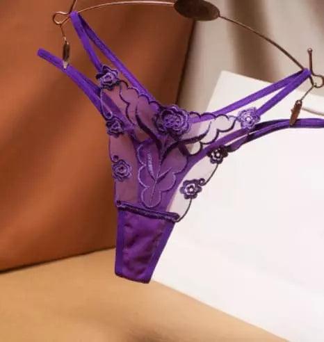 Calcinha fio dental roxa com renda delicada, design transparente e detalhes florais elegantes.
